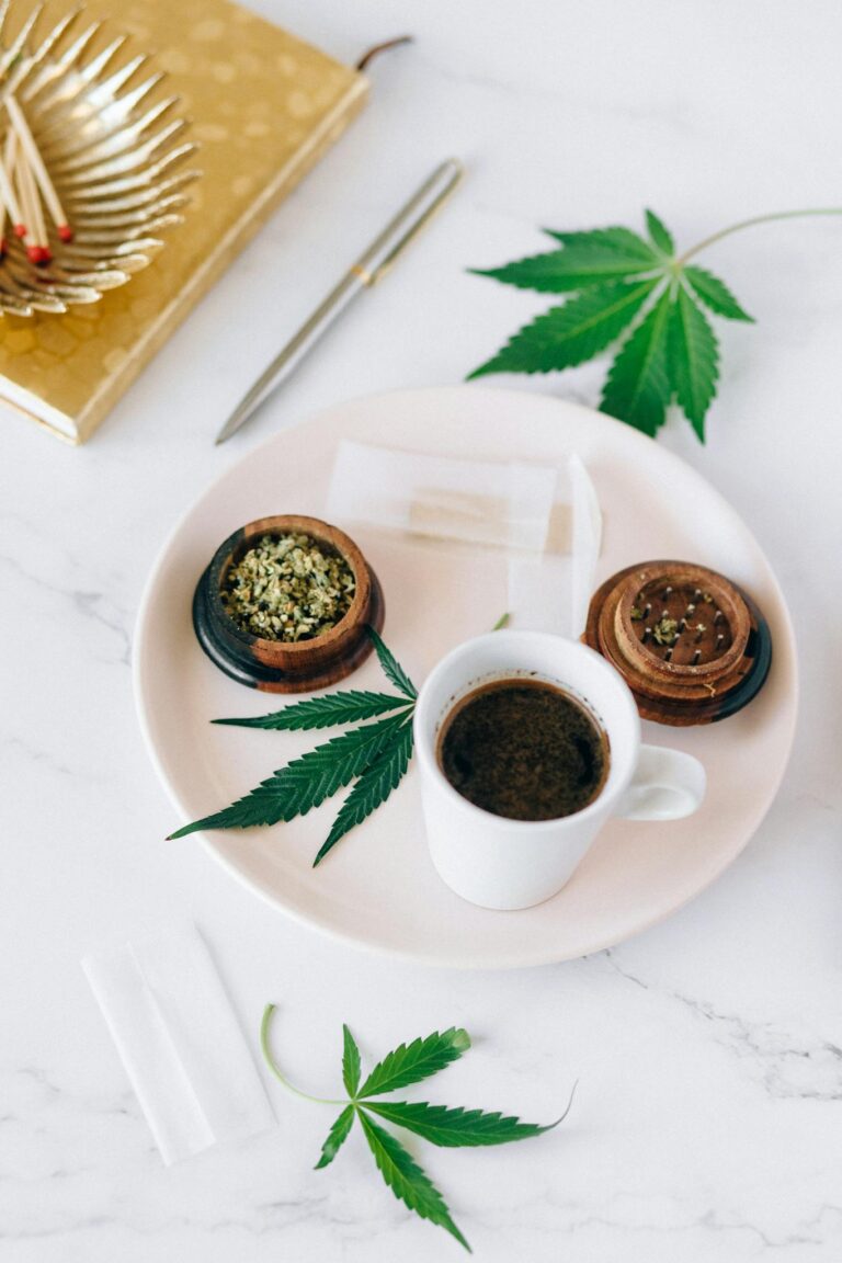 Aesthetic arrangement of coffee and cannabis leaves on a marble surface, ideal for lifestyle themes.